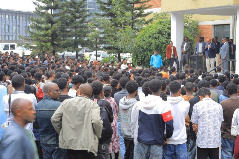 Education Minister Berhanu Nega speaking from the steps on the right to a large crowd of students filling the forecourt of the Ministry of Education.