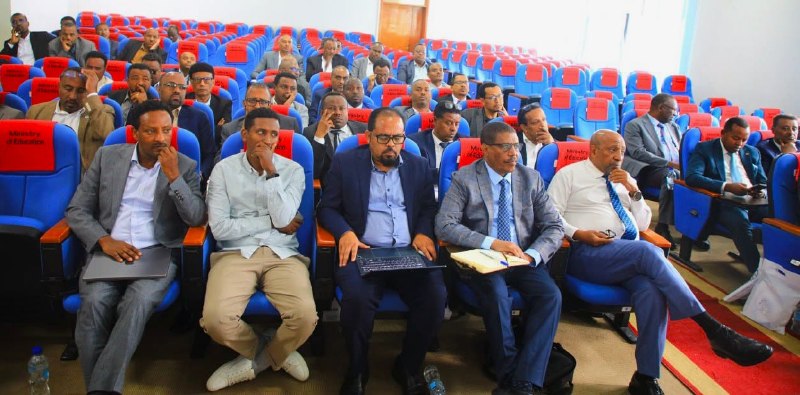 የዩኒቨርሲቲ አዳራሽን የሞሉ በረድፍ የተቀመጡ ተሳታፊዎች፤ የፊተኛው ረድፍ ላይ ሱፍ የለበሱ ሰዎች ላፕቶፕና ደብተር በጭናቸው ይዘዋል።